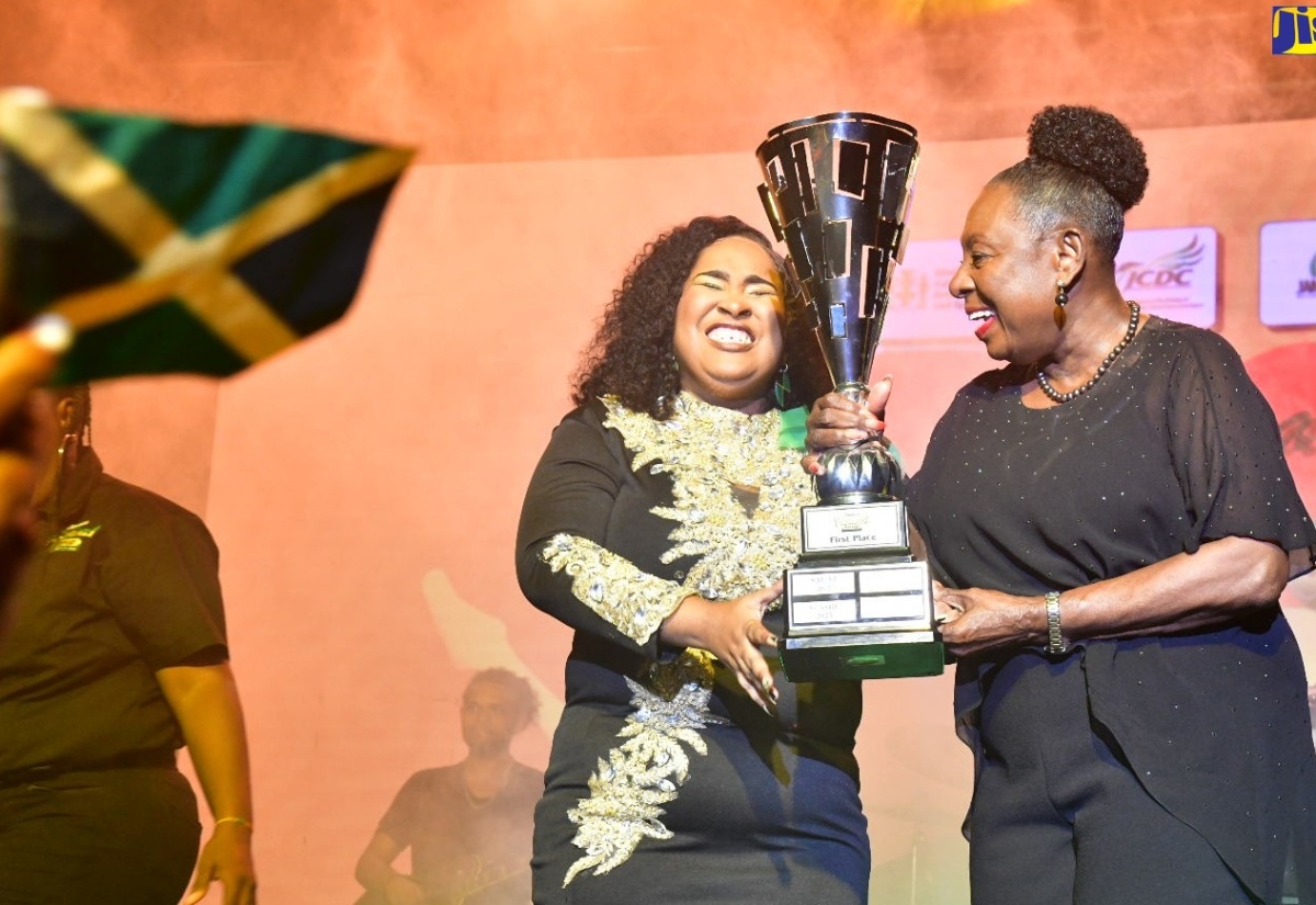 Culture, Gender, Entertainment and Sport Minister, Hon. Olivia Grange (right), presents the Jamaica Festival Song trophy to 2024 winner, Kimiela ‘Candy’ Isaacs , who walked away with the coveted trophy for her original entry ‘One Jamaica’. The finals of the Jamaica Cultural Development Commission (JCDC) competition took place on July 13, at the Jamaica College Auditorium in Kingston. 