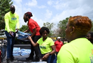 Representatives from Digicel Foundation and Jamaica Public Service (JPS) Foundation unload tarpaulins for distribution to residents of St. Elizabeth impacted by the recent passage of Hurricane Beryl. The entities, in collaboration with Flow Foundation and Food For the Poor, delivered care packages to residents of Parottee, Slipe and Crawford, among other areas on July 10.

