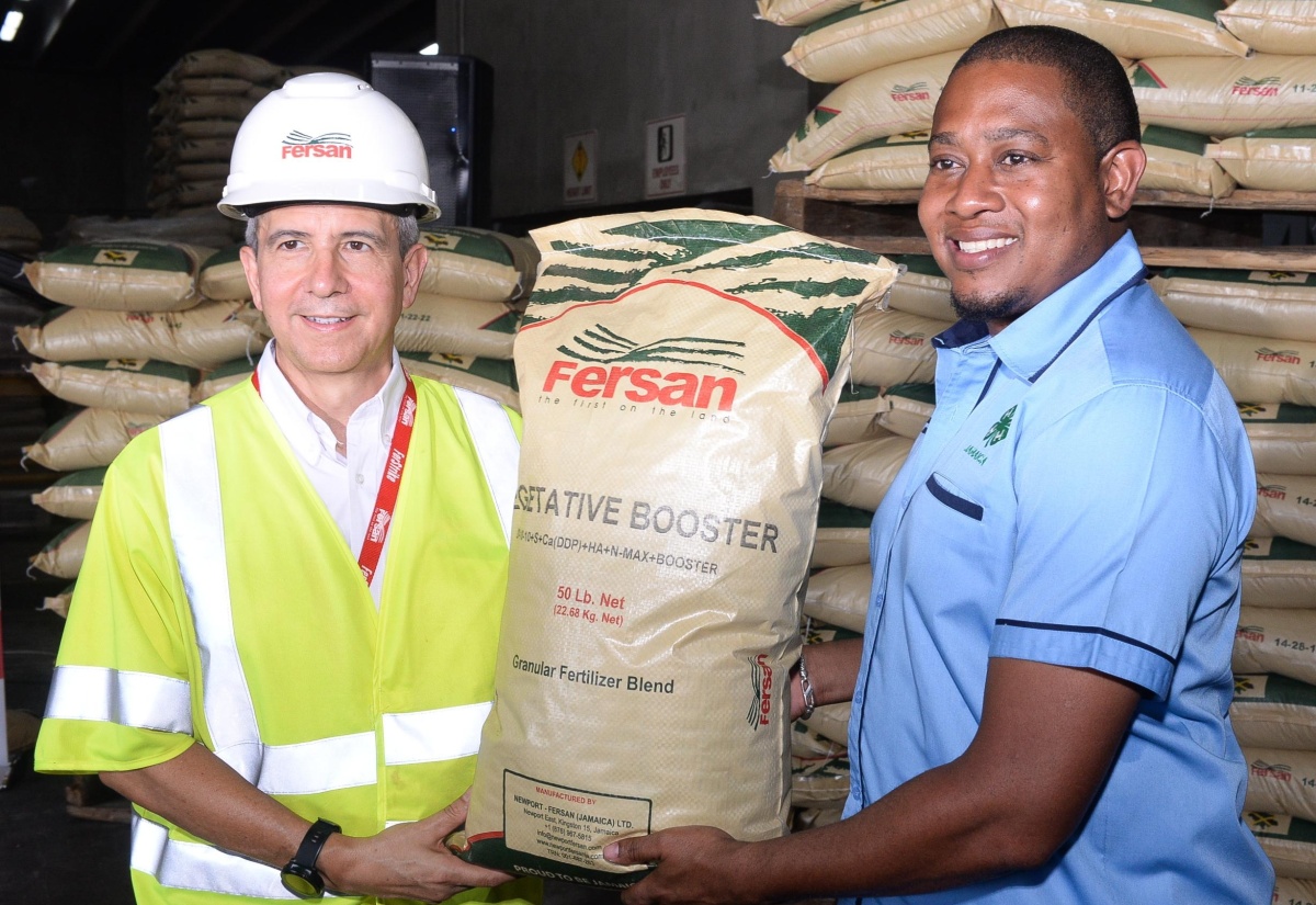 Minister of Agriculture, Fisheries and Mining, Hon. Floyd Green (right), receives a donation of granular fertiliser blend from Managing Director of Newport-Fersan (Jamaica) Limited, Dennis Valdez (left), during the Hurricane Recovery Support Ceremony on Tuesday (July 30), at the company’s Wherry Wharf Complex in Kingston.