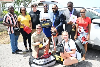Mayor of Black River and Chairman of the St. Elizabeth Municipal Corporation, Councillor Richard Solomon (third right, standing), and other representatives of the Corporation are joined by My Medic Training + Response President, John Lyon (third left, standing), and his team during the handover of equipment on Thursday (July 11) to aid post-Hurricane Beryl relief efforts in the parish.