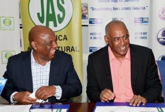Chairman of the United Way of Jamaica, Dr. Devon Smith (left), sharing pleasantries with Senior Strategist, Ministry of Agriculture, Fisheries and Mining, Michael Pryce, during the launch of the farmers’ rehabilitation fund, at the Private Sector Organisation of Jamaica offices in St. Andrew, on July 12.