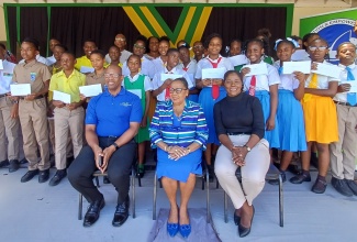 Custos of St. Catherine, Hon. Icylin M. Golding (centre, seated); Chairman of the Poverty Alleviation and Empowerment Foundation (PAEF), Devon Samuels (left), and Executive Director of the Foundation, Pauline Gregory-Lewis (right), with the 30 students in St. Catherine who were awarded scholarships worth $375,000 by the PAEF, at the Parish Office of the Social Development Commission, in Spanish Town, recently. Teachers and officials of the Foundation are also pictured.

