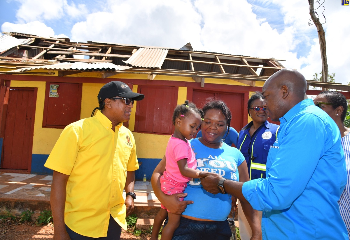 Minister of Labour and Social Security, Hon. Pearnel Charles Jr. (right) greets resident of Salmon Town in Manchester, Ann Kay Dixon and daughter (second left), during a tour of the area on July 12. Ann Kay’s house and business were damaged as a result of the passage of hurricane beryl.  Looking on is the Minister of State in the Ministry, Dr. Hon. Norman Dunn.