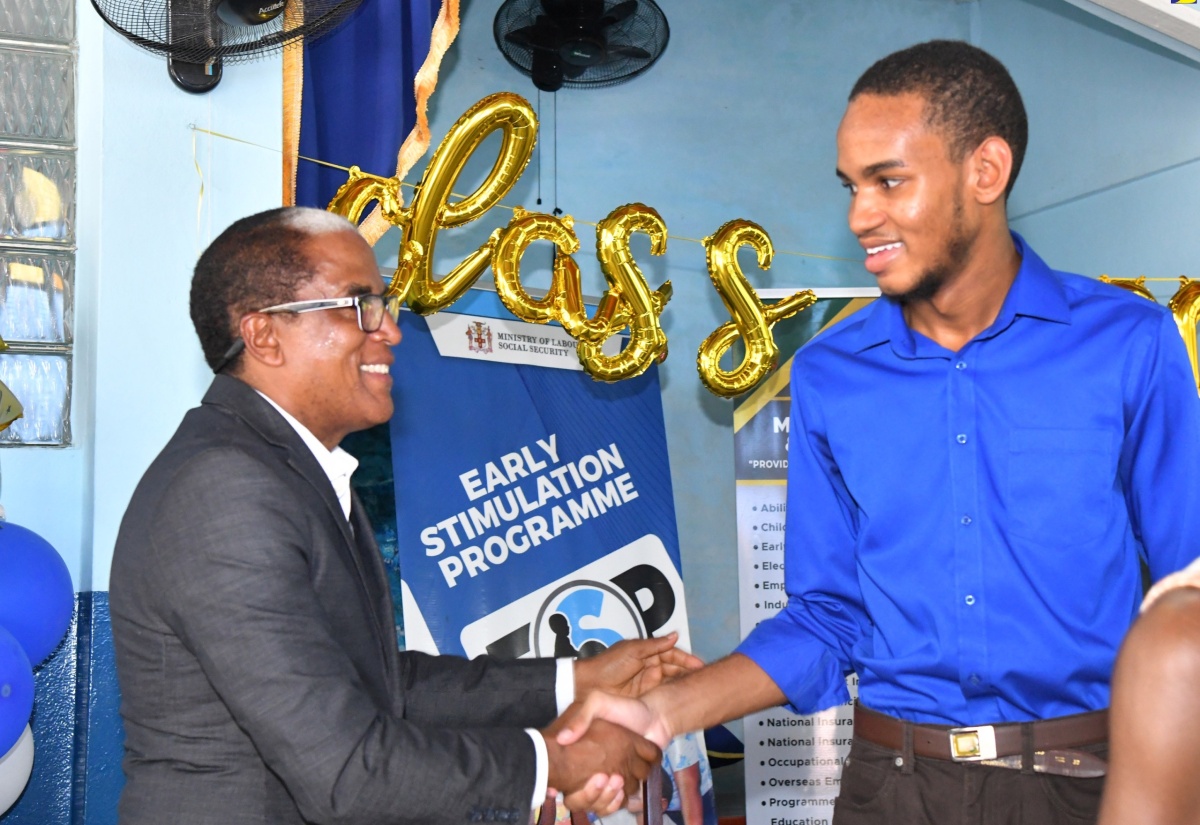 State Minister in the Ministry of Labour and Social Security, Dr. the Hon. Norman Dunn (left) greets past student of the Ministry’s Early Stimulation Programme, Joshua Hall during the staging of the programme’s 2024 graduation exercise held on July 10 at the Apostolic Church of Jamaica Bethel Temple in Kingston.

