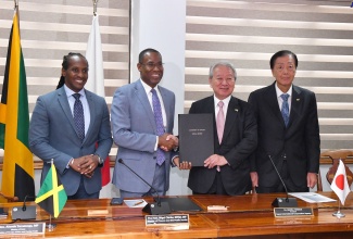 Minister of Finance and the Public Service, Dr. the Hon. Nigel Clarke (second left), and Japan International Cooperation Agency (JICA) President, Dr. Akihiko Tanaka (second right), display the signed Memorandum of Cooperation (MOC) that will promote collaboration in the areas of disaster risk management, climate change, security and economic development. The signing ceremony was held at the Ministry of Finance and the Public Service in Kingston on Wednesday (July 31). Sharing the moment (from left) are State Minister in the Ministry of Foreign Affairs and Foreign Trade, Hon. Alando Terrelonge; and Ambassador of Japan to Jamaica, His Excellency Yasuhiro Atsumi. 