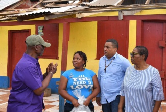 Minister of Local Government and Community Development, Hon. Desmond McKenzie (left), in discussion with Annakay Dixon (second left), during a tour of the Salmond Town community of South Manchester on July 12. Others present (from second right) are Member of Parliament for Manchester Southern, Robern Chin, and Councillor for the Grove Town Division, Iceval Brown.