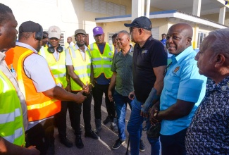 Minister of Health and Wellness, Dr. the Hon. Christopher Tufton (third right), in conversation with a vector-control team working in the community of Rocky Point, Clarendon, on July 25. Others pictured are (from right) Councillor for the Rocky Point Division, Winston Maragh; Member of Parliament for Clarendon South Eastern, Hon. Pearnel Charles Jr.  and Deputy Chairman for the Southern Regional Health Authority (SRHA), Michael Stern.