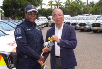 Minister of National Security, Hon. Dr. Horace Chang (right), hands over keys to 40 new vehicles, valued over $313 million, to Commissioner of Police, Dr. Kevin Blake, at a handover ceremony, held on July 31 at the Office of the Commissioner in St. Andrew.