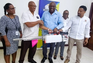 Mayor of Savanna-la-Mar, Councillor Danree Delancy (centre), hands over a fogging machine to Chief Public Health Inspector at the Westmoreland Public Health Department, Steve Morris (second left), at the Westmoreland Municipal Corporation’s offices in the parish on July 18. Sharing the moment  (from left) are Acting Medical Officer of Health for Westmoreland, Dr. Zainab Maiyaki; Accountant at the Corporation, Carolissa Simpson and Acting Chief Executive Officer at the Municipality, Marcus Bromfield. 