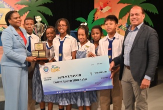 Permanent Secretary in the Ministry of Tourism, Jennifer Griffith (left), presents the championship trophy to winner of the 2024 Tourism Product Development Company (TPDCo) Tourism Quiz Competition, Hosanna Preparatory. Also photographed is TPDCo Board Chairman, Ian Dear (right). 

