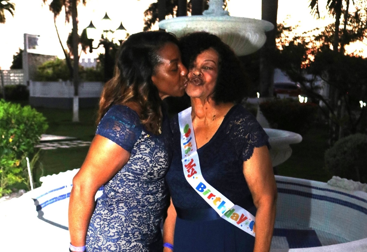 Eighty-year-old Salome Ogilvie (right) receives a kiss from daughter Celia Ogilvie at a special birthday celebration held at Sea Garden Beach Resort in Montego Bay, St. James on August 10.