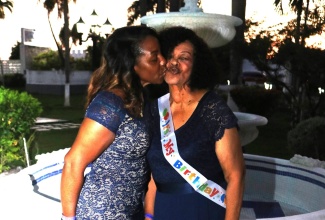 Eighty-year-old Salome Ogilvie (right) receives a kiss from daughter Celia Ogilvie at a special birthday celebration held at Sea Garden Beach Resort in Montego Bay, St. James on August 10.