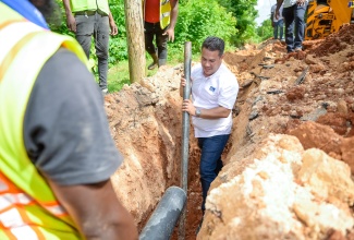 Minister without Portfolio in the Ministry of Economic Growth and Job Creation, Senator the Hon. Matthew Samuda, assists with pipeline installations during a tour of the Mason Hall Water Supply System in St. Mary on Thursday (August 22).