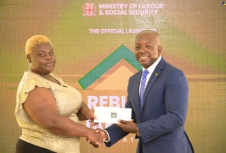 Prime Minister, the Most Hon. Andrew Holness, embraces grant recipient, Pauline Smith, of Grange Hill in Westmoreland, at the launch of the Rebuild Jamaica Initiative, held at the Ministry of Labour and Social Security offices in Kington, on August 5.