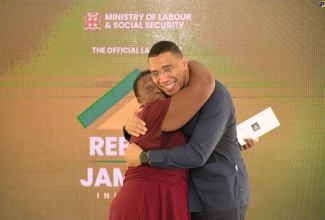 Prime Minister, the Most Hon. Andrew Holness, embraces grant recipient, Pauline Smith, of Grange Hill in Westmoreland, at the launch of the Rebuild Jamaica Initiative, held at the Ministry of Labour and Social Security offices in Kington, on August 5.