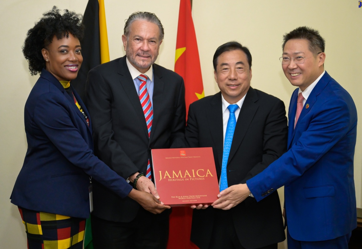 President of the Senate, Senator the Hon. Thomas Tavares-Finson (second left), presents a gift to Vice Chairman of the Standing Committee of Shandong Provincial People's Congress, Sun Licheng (second right), during a courtesy call at Gordon House on Thursday (August 8). Sharing the moment (from left) are Clerk to the Houses of Parliament, Colleen Lowe and Chinese Ambassador to Jamaica, His Excellency Chen Daojiang.

