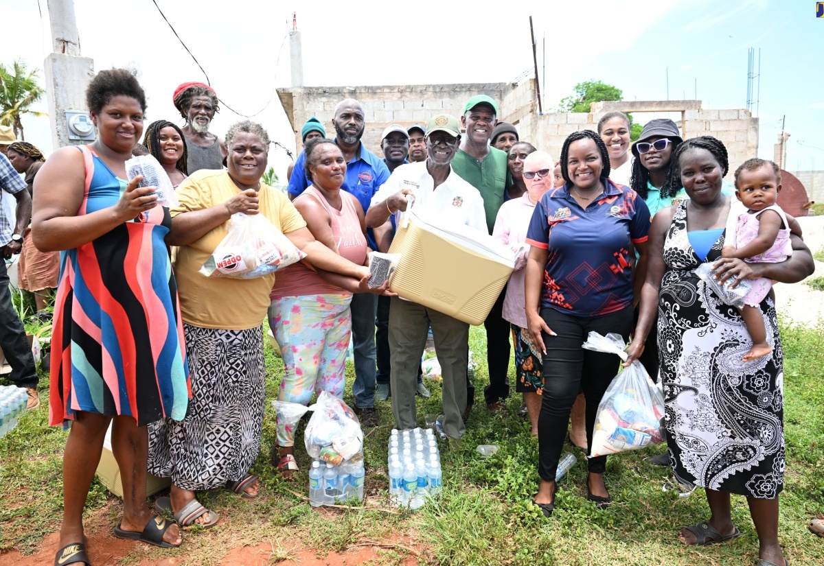 Minister of Local Government and Community Development, Hon. Desmond McKenzie (centre), is surrounded by residents of Flagaman during a tour of sections of St. Elizabeth on Saturday (August 10) to get a first-hand look at hurricane damage and distribute relief items.

