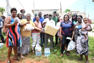 Minister of Local Government and Community Development, Hon. Desmond McKenzie (centre), is surrounded by residents of Flagaman during a tour of sections of St. Elizabeth on Saturday (August 10) to get a first-hand look at hurricane damage and distribute relief items.

