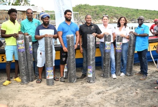 Minister of Agriculture, Fisheries and Mining, Hon. Floyd Green (fourth right), with fishers after donating rolls of mesh wire during a handover ceremony at Great Bay Fishing Beach, Treasure Beach, St. Elizabeth, on August 22. Also sharing the moment are Principal Director of Technical Services at the Rural Agricultural Development Authority (RADA), Winston Simpson (right); Operations Director at Sandals Foundation, Karen Zacca (second right); and  Director of the Sandals Foundation, Heidi Clarke (third right).