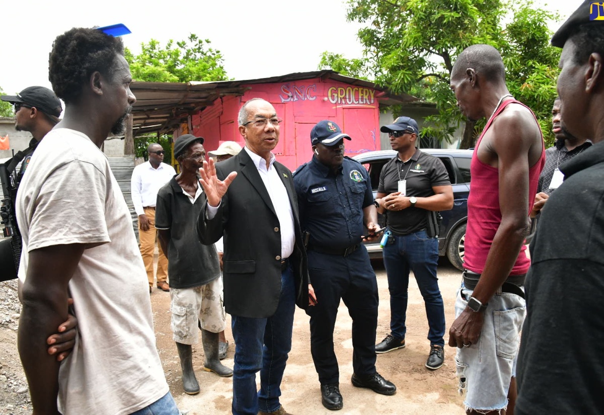 Minister of National Security, Hon. Dr. Horace Chang (second left), addresses residents of the Cherry Tree Lane community in Clarendon, on August 12.

