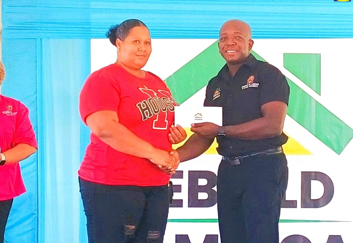 Minister of Labour and Social Security, Hon. Pearnel Charles Jr., presents a grant cheque to St. Elizabeth resident, Maricka Aiken, during the Rebuild Jamaica Initiative handover ceremony, held at the Ministry’s office in Santa Cruz, on Thursday  (August 29). 