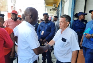 Executive Director, National Solid Waste Management Authority (NSWMA), Audley Gordon (left), greets Chief Operating Officer, Bashco Trading, Juan Machado, during a recent walk-through of the downtown Kingston business district. The NSWMA was among the government entities participating in a multi-agency operation in the area, aimed at ensuring businesses adhere to the country’s laws. The operation, conducted between August 14 and 16, was led by the Kingston and St. Andrew Municipal Corporation (KSAMC).

