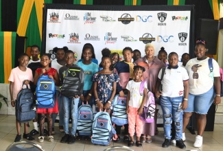 Executive Director, Pollyanna Project, Donna Stewart Moore (fifth right), with some of the students who recently got educational support from the organisation, at an event held at the Lions Civic Centre in Old Harbour, St. Catherine.

