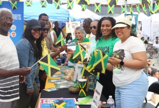 Deputy Chief of Mission at the Embassy of Jamaica in Washington DC, Lishann Salmon (right), along with members of staff, distributes Jamaican flags to persons who visited the Jamaican booth display during the third annual ‘Jamaica Fest’, which was held August 18 at Veterans Plaza in Silver Spring, Maryland.

