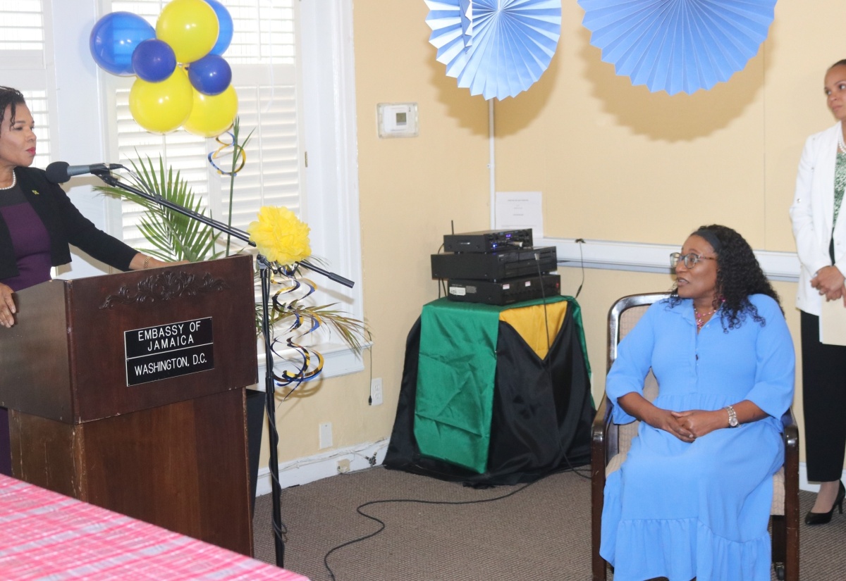 Jamaica’s Ambassador to the United States, Her Excellency Audrey Marks (left), pays tribute to outgoing accountant at the Embassy of Jamaica in Washington DC, Georgette Smith (seated), for her outstanding service at the Mission. The occasion was a farewell reception for Ms. Smith at the Embassy on August 22. Ms. Smith was also hailed for her over 30 years of service to the Ministry of Foreign Affairs and Foreign Trade.

