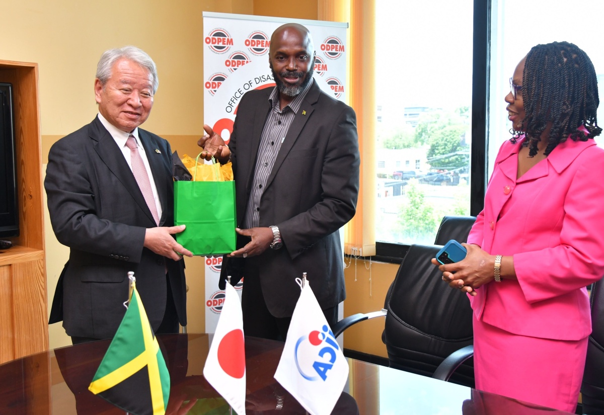 Acting Director General, Office of Disaster Preparedness and Emergency Management (ODPEM), Richard Thompson (centre), presents a gift to President, Japan International Cooperation Agency (JICA), Akihiko Tanaka, during his courtesy call and site visit at ODPEM’s head office on Haining Road in Kingston on Wednesday (July 31). Looking on is Permanent Secretary in the Ministry of Local Government and Community Development, Marsha Henry-Smith. Mr. Tanaka and other JICA officials were updated during the visit on the Improvement of Emergency Communication System Project in Jamaica, a collaborative effort between ODPEM and the Agency.