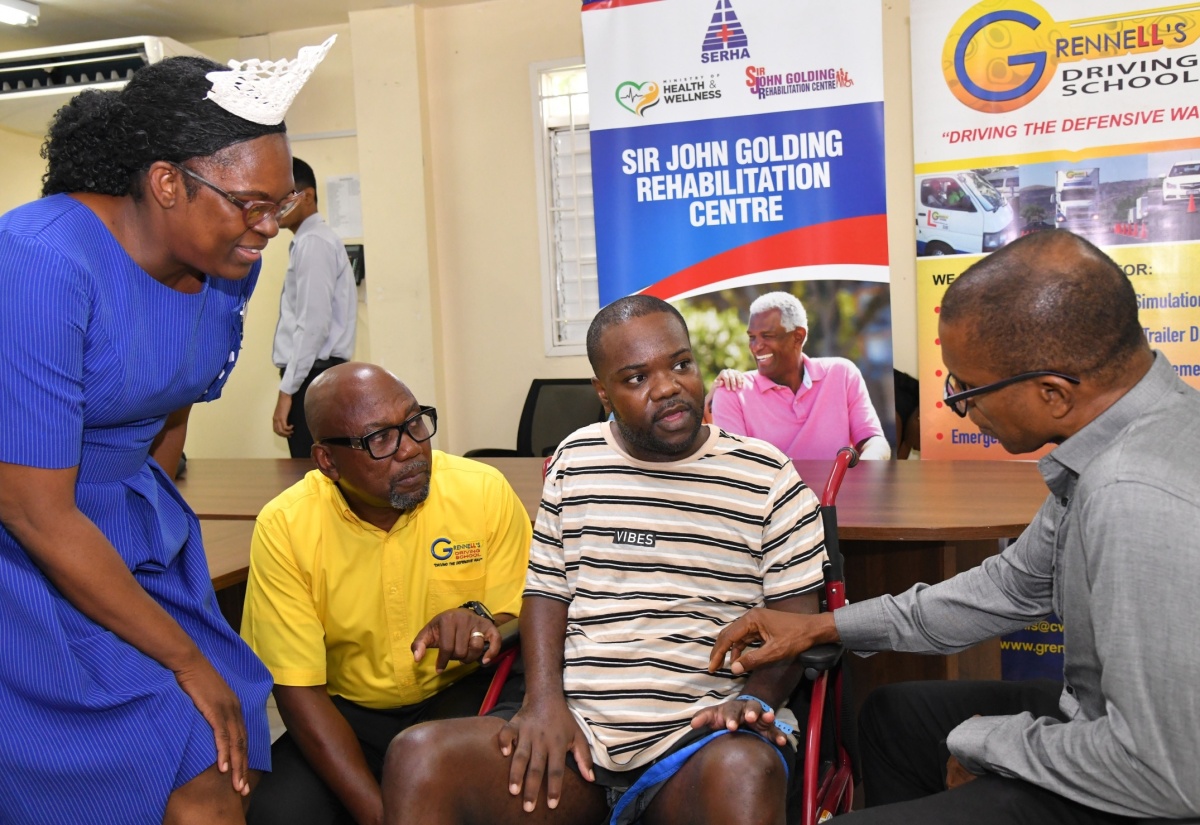 Chief Medical Officer at the Sir John Golding Rehabilitation Centre, Dr. Rory Dixon (right), in discussion with crash survivor, Oraine Elliot (second right), at the media launch of the Grennell's Road Safety 5k Run, held on August 2 at the centre, in St. Andrew. Also pictured (from left) are Director of Nursing at the centre, Andrea Christie, and Director of Grennell Driving School, Alphanso Grennell.

