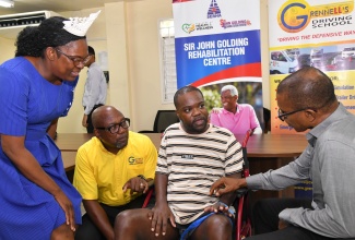 Chief Medical Officer at the Sir John Golding Rehabilitation Centre, Dr. Rory Dixon (right), in discussion with crash survivor, Oraine Elliot (second right), at the media launch of the Grennell's Road Safety 5k Run, held on August 2 at the centre, in St. Andrew. Also pictured (from left) are Director of Nursing at the centre, Andrea Christie, and Director of Grennell Driving School, Alphanso Grennell.