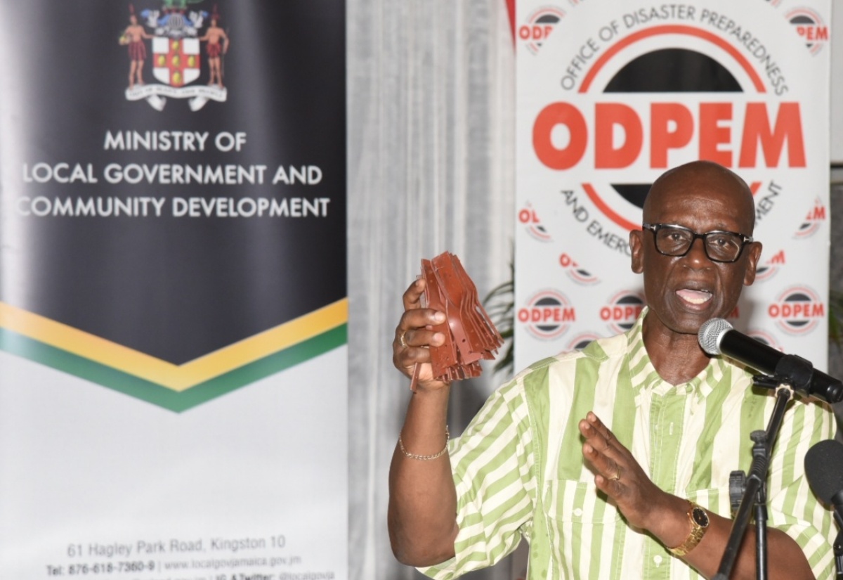 Minister of Local Government and Community Development, Hon. Desmond McKenzie, displays hurricane roof straps while addressing a ceremony on August 26, at the Hugh Lawson Shearer Community Centre in Rocky Point, Clarendon, where the Government commenced its distribution of 10,000 of the straps.

