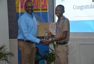 Tourism Director, Donovan White, presents winner of the Jamaica Tourist Board (JTB) 2024/25 Junior Minister of Tourism Competition, 16-year-old student of Manning’s School in Westmoreland, Taj Melbourne, with his prizes following the finals, held recently at Beaches Ocho Rios in Boscobel, St. Mary.