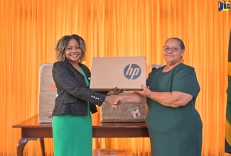 Minister without Portfolio in the Office of the Prime Minister with Responsibility for Information, Skills and Digital Transformation, Senator Dr. the Hon. Dana Morris Dixon (left), is presented with a computer by Premier of the Cayman Islands, Hon. Juliana O'Connor-Connolly at the Office of the Prime Minister in Kingston on Monday (August 5). The Cayman Islands Premier handed over 40 devices in continuation of her country’s support to Jamaica’s recovery in the aftermath of Hurricane Beryl. On July 18, Mrs. O'Connor-Connolly presented US$200,000 and an assortment of medical equipment to Prime Minister, the Most. Hon. Andrew Holness.