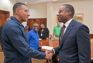 Prime Minister the Most. Hon. Andrew Holness (left), greets President and Chief Executive Officer the at Jamaica Public Service Company (JPS), Hugh Grant, during a meeting with the executive team of the JPS at the Office of the Prime Minister on Monday (August 5).
