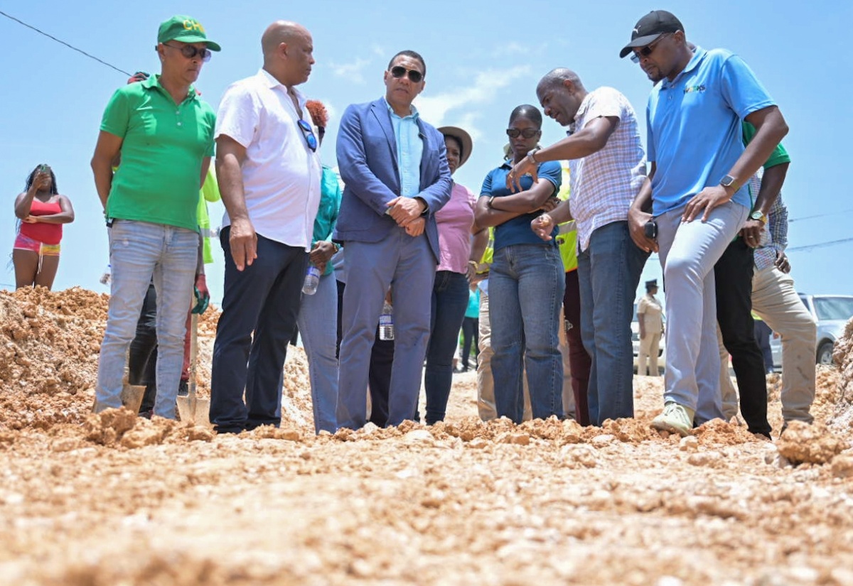 Prime Minister, the Most Hon. Andrew Holness (third left), and Minister without Portfolio in the Ministry of Economic Growth and Job Creation, Hon. Robert Morgan (right), observe repair works being done on a section of the Pamphret main road in St. Thomas, on August 14. Also pictured are (from left) Mayor of Morant Bay, Councillor Louis Chin; Member of Parliament for St. Thomas Western, James Robertson; Television Jamaica journalist, Jamaila Maitland; and Senior Director at the National Works Agency, Varden Downer.

