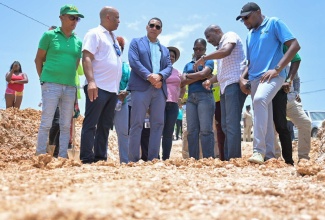 Prime Minister, the Most Hon. Andrew Holness (third left), and Minister without Portfolio in the Ministry of Economic Growth and Job Creation, Hon. Robert Morgan (right), observe repair works being done on a section of the Pamphret main road in St. Thomas, on August 14. Also pictured are (from left) Mayor of Morant Bay, Councillor Louis Chin; Member of Parliament for St. Thomas Western, James Robertson; Television Jamaica journalist, Jamaila Maitland; and Senior Director at the National Works Agency, Varden Downer.

