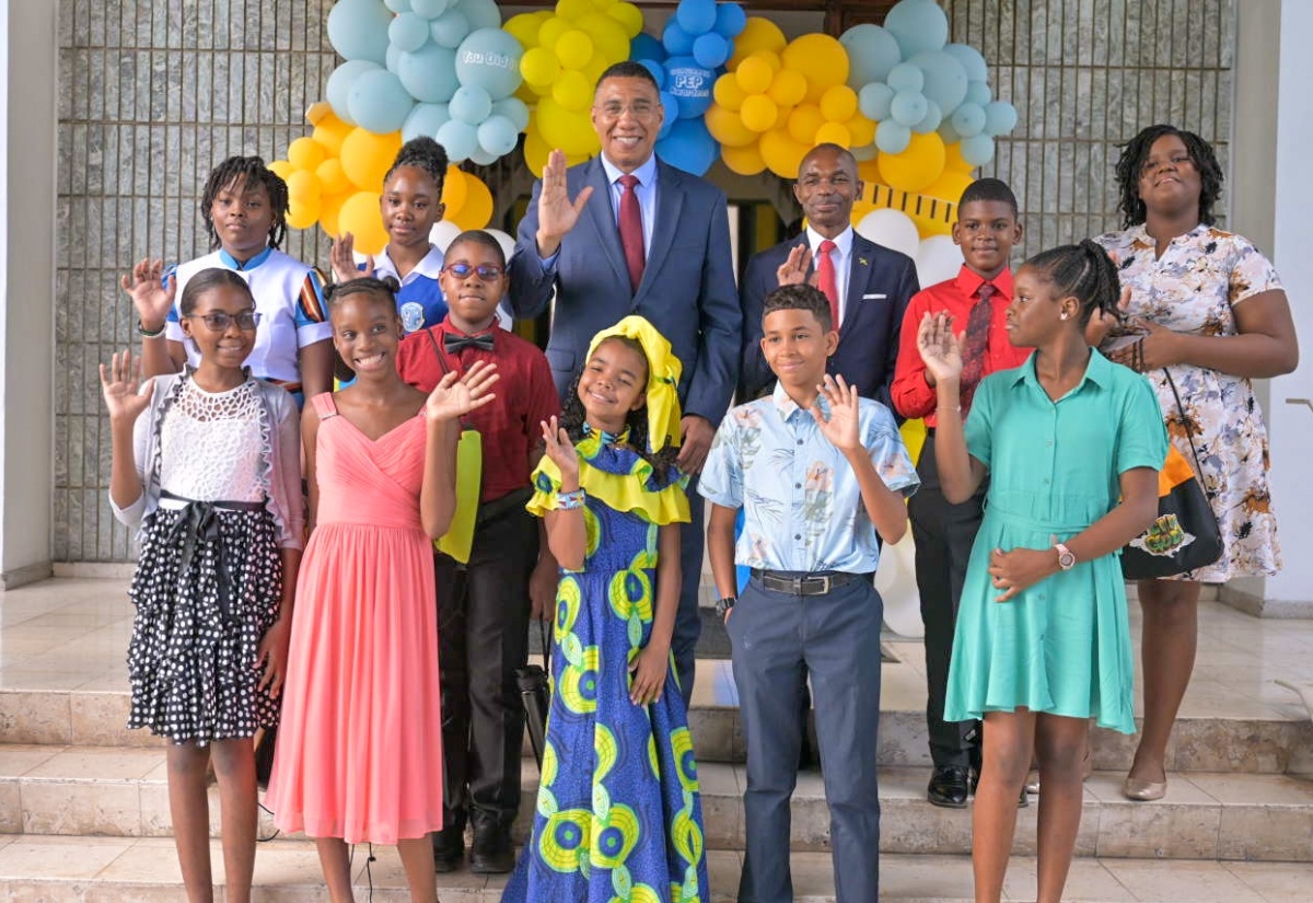 Prime Minister, the Most Hon. Andrew Holness (third left, background) and Permanent Secretary in the Office of the Prime Minister, Ambassador Dr. Rocky Meade (third right, background) with some of the children of employees of the Office of the Prime Minister and the Cabinet Office, who were successful in the Primary Exit Profile (PEP) examinations held earlier this year. The awards function was held at Banquet Hall, Jamaica House, on Thursday (August 29).