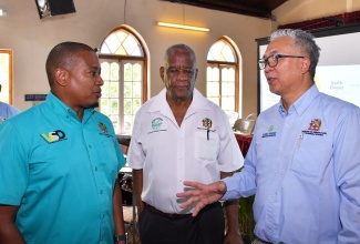 Minister of Agriculture, Fisheries and Mining, Hon. Floyd Green (left), converses with Chief Executive Officer (CEO), Agro-Investment Corporation, Vivion Scully (right), during the entity’s recent lease handover ceremony in Lydford, St. Ann. Listening is State Minister in the Ministry of Agriculture,  Franklin Whitter. 

