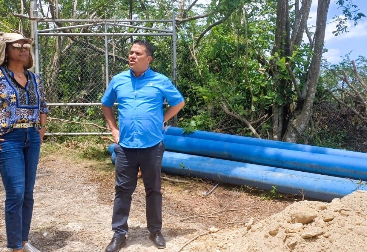 Minister without Portfolio in the Ministry of Economic Growth and Job Creation, Senator the Hon. Matthew Samuda (right), converses with Minister of Legal and Constitutional Affairs and Member of Parliament for St. James West Central, Hon. Marlene Malahoo Forte, during a visit to the site of the National Water Commission's pipe-laying project in Fairfield Irwin, St. James, on Monday (August 19). 

