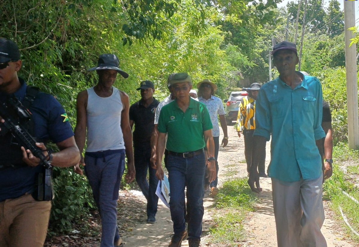 Minister of National Security, Hon. Dr. Horace Chang (centre), tours sections of Paradise, Norwood and Glendevon in Montego Bay, St. James, on August 23.  

