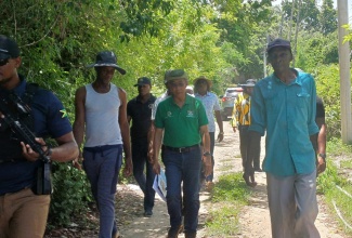 Minister of National Security, Hon. Dr. Horace Chang (centre), tours sections of Paradise, Norwood and Glendevon in Montego Bay, St. James, on August 23.  

