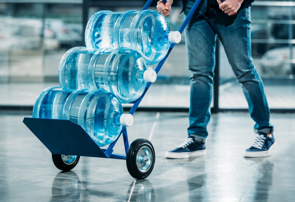 Loader pushing cart with water bottles