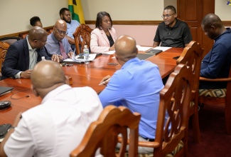 Minister without Portfolio in the Ministry of Economic Growth and Job Creation with responsibility for Works, Hon. Robert Nesta Morgan (head of table), addresses a meeting with representatives of the Incorporated Master Builders Association of Jamaica at the Ministry’s New Kingston offices on Wednesday (September 18). He is joined by (from left) Senior Director at the National Works Agency (NWA), Varden Downer;  Chief Executive Officer at the NWA, Everton G. Hunter; and Permanent Secretary in the Ministry, Arlene Williams.