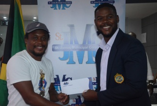 Mayor of Montego Bay and Chairman of the St James Municipal Corporation, Councillor Richard Vernon (right), hands over a Local Economic Development (LED) grant to local entrepreneur, Ricardo James, during the Grant Distribution Meeting at the Corporation’s Cambers, on September 18.

