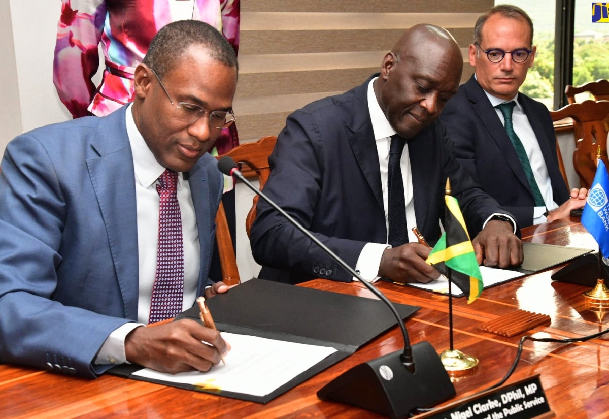 Minister of Finance and the Public Service, Dr. the Hon. Nigel Clarke (left), and Managing Director, International Finance Corporation (IFC), Makhtar Diop (centre), sign the Memorandum of Understanding (MOU), formalising the IFC as Jamaica’s strategic advisor on a portfolio of Public-Private Partnership (PPP) projects. Observing the proceedings is IFC Vice President for Europe, Latin America and the Caribbean, Alfonso García Mora.

