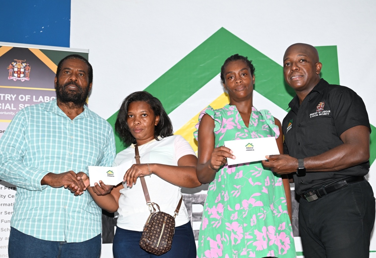 Minister of Labour and Social Security, Hon. Pearnel Charles Jr. (right), is joined by Member of Parliament for Westmoreland Eastern, Daniel Lawrence, in presenting cheques to residents of the parish, Carole Jones (second left) and Camele Campbell, to assist with repairs to their homes, which were damaged during Hurricane Beryl’s passage. The cheques were handed over during a ‘Rebuild Jamaica’ presentation ceremony at The Source in Savanna-la-Mar, on August 29.

