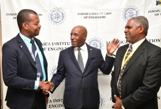 Minister of Industry, Investment & Commerce, Senator the Hon. Aubyn Hill (centre) engages in conversation with President of the Jamaica Institution of Engineers (JIE), Oneil Josephs (left) and Chairperson, Professional Engineering Registration Board (PERB), Glaister Ricketts, at the opening of JIE Engineers' Week Conference & Expo at The Jamaica Pegasus hotel on Monday (September 16)

