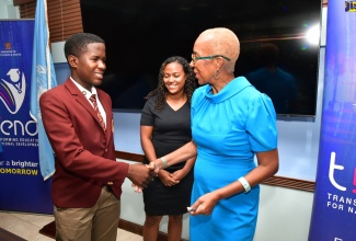 Minister of Education and Youth, Hon. Fayval Williams, is greeted by Chair of the Jamaica Prefects’ Association and student of Wolmer’s Boys, Aimar Sterling (left), during the launch of the Music and Arts for Change Competition at the Ministry’s offices in Kingston on Wednesday (September 18). Looking on is Project Advisor, United Nations Regional Centre for Peace, Disarmament and Development in Latin America and the Caribbean, Fayola Fraser.  